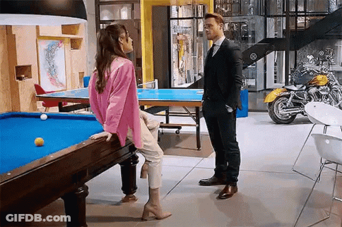 Young Man In Glasses And Black Jacket By Statue GIF