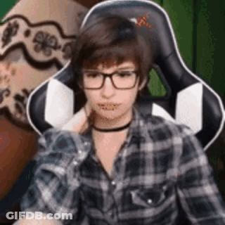 Young Man In Glasses And Plaid Shirt Sitting GIF