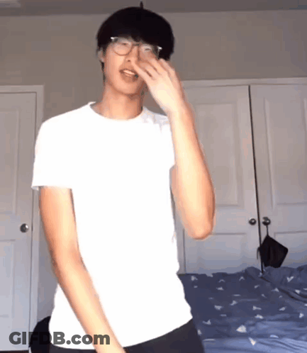 Young Man In Glasses And White Shirt By Bed GIF