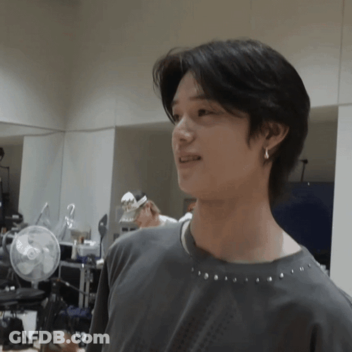 Young Man In Gray Shirt And Earrings By Mirror GIF