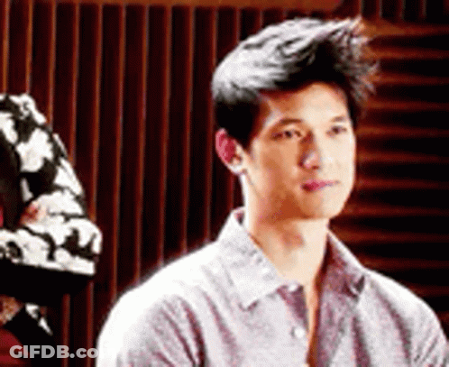Young Man In Gray Shirt Sitting In Chair GIF