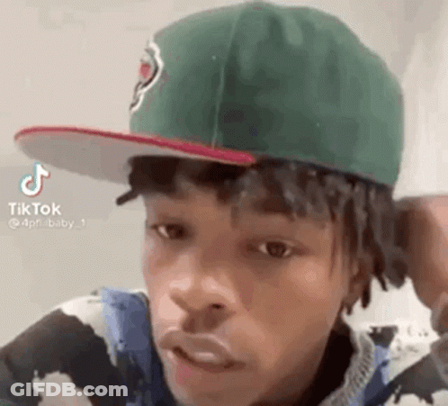 Young Man In Green Hat And Cow Print Shirt GIF