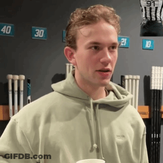 Young Man In Green Hoodie In Front Of Numbered Wall GIF