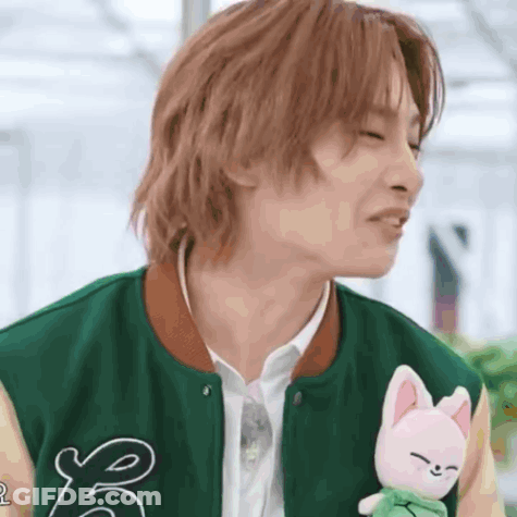 Young Man In Green Jacket Holding Stuffed Animal GIF