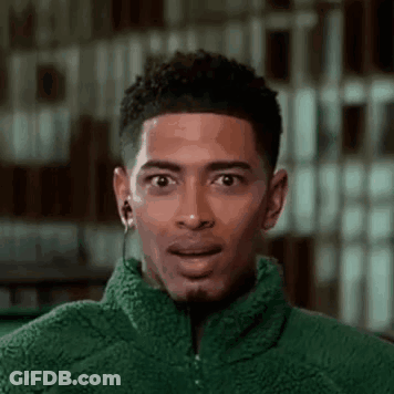Young Man In Green Jacket With Earbuds Surprised GIF