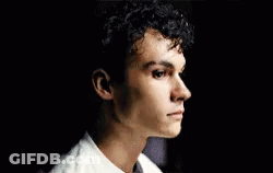 Young Man In Green Shirt Sitting On Couch Eyes Closed GIF