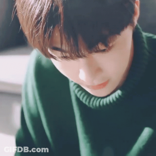 Young Man In Green Sweater Looking Down GIF