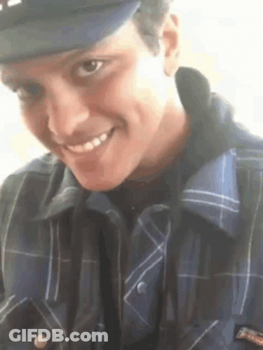 Young Man In Hat And Plaid Shirt Smiling GIF