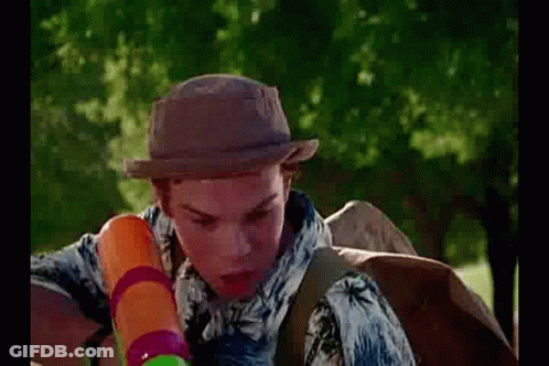 Young Man In Hat Holding Water Gun Next To Water Bottle GIF