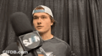 Young Man In Hat Talking Into Microphone GIF