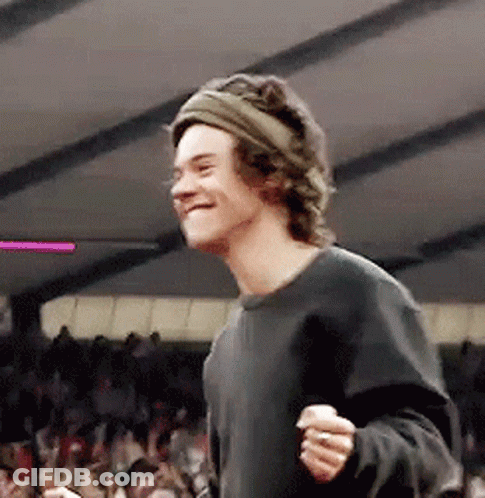 Young Man In Headband And Black Shirt Smiling In Crowd GIF