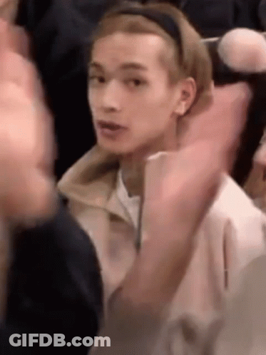 Young Man In Headband Sitting In Crowd GIF