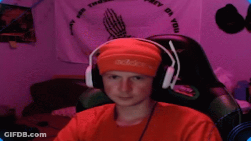Young Man In Headphones And Orange Beanie Sitting In Chair GIF