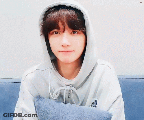 Young Man In Hoodie Sitting On Couch With Pillow GIF
