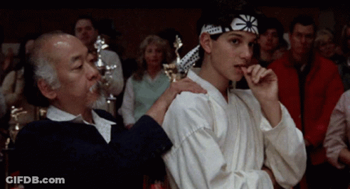 Young Man In Karate Headband Next To Older Man GIF