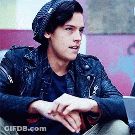 Young Man In Leather Jacket And Beanie Sitting On Floor GIF