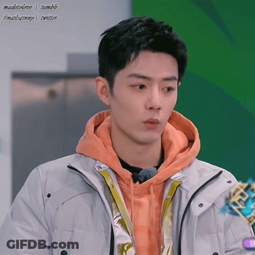 Young Man In Orange Hoodie And White Jacket GIF
