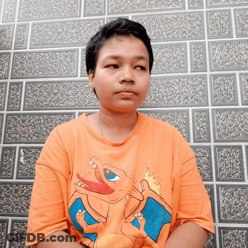 Young Man In Orange Shirt With Cartoon Character GIF