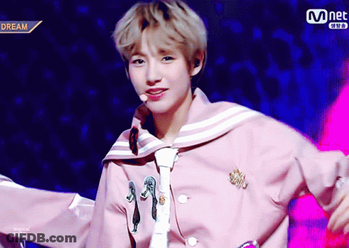 Young Man In Pink Jacket And Tie In Front Of Mnet Logo GIF