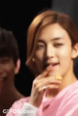Young Man In Pink Shirt Eating Lemon Slice GIF