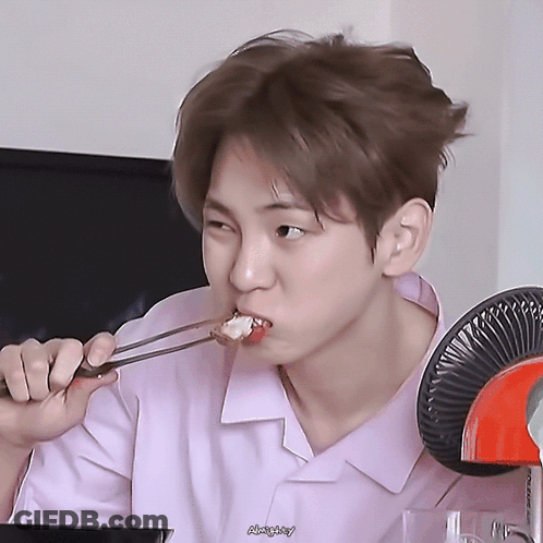 Young Man In Pink Shirt Eating With Chopsticks GIF