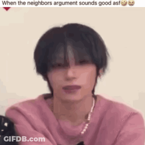 Young Man In Pink Sweater And Necklace Sitting GIF