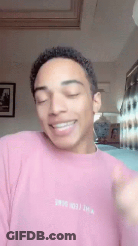 Young Man In Pink Sweater Smiling Making Funny Face GIF
