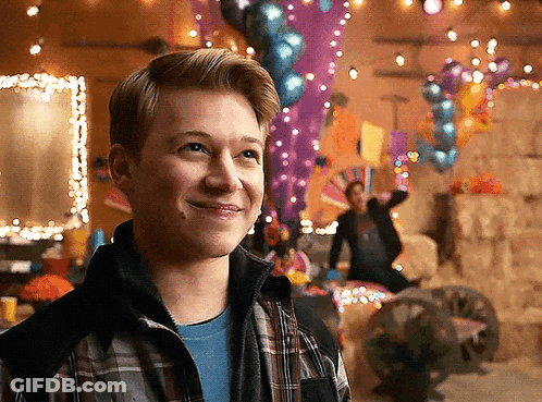 Young Man In Plaid Jacket Smiling With Balloons GIF