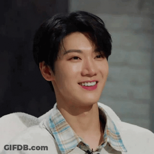 Young Man In Plaid Shirt And White Sweater Smiling GIF
