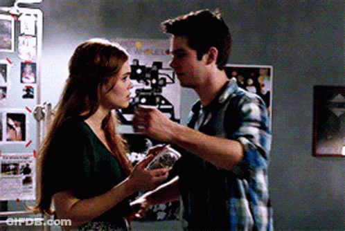 Young Man In Plaid Shirt Leaning Against Wall Looking Up GIF