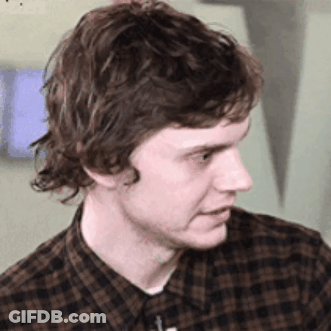 Young Man In Plaid Shirt Looking To Side GIF