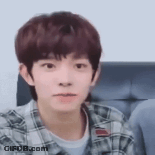 Young Man In Plaid Shirt Making Funny Face On Couch GIF