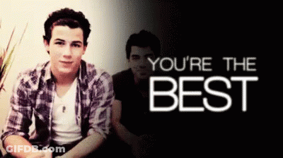 Young Man In Plaid Shirt Sitting In Front Of You're The Best Sign GIF