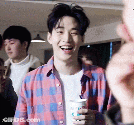 Young Man In Plaid Shirt Smiling Holding Coffee GIF