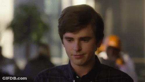 Young Man In Plaid Shirt Smiling Looking Down GIF