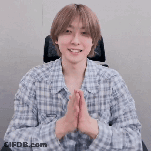 Young Man In Plaid Shirt Smiling With Hands Folded GIF
