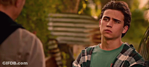 Young Man In Plaid Shirt Talking To Another Man By Car GIF