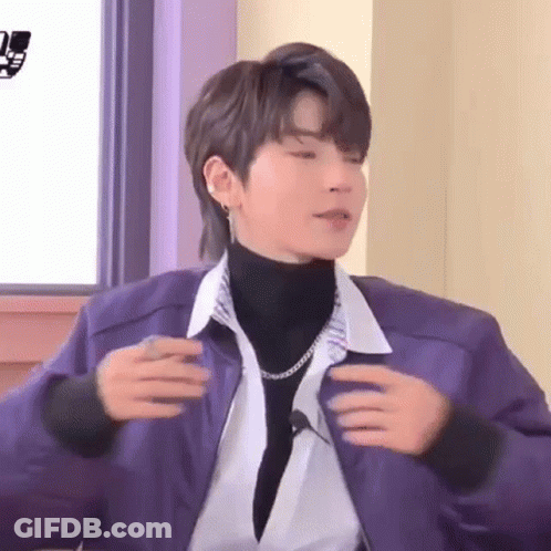 Young Man In Purple Jacket And Turtleneck Sitting GIF