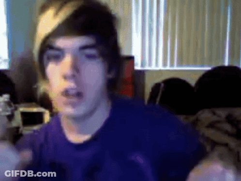 Young Man In Purple Shirt And Beanie Looking At Camera GIF
