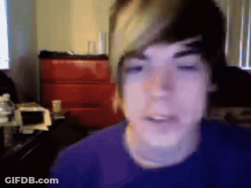 Young Man In Purple Shirt Looking At Camera GIF
