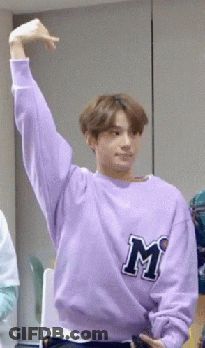 Young Man In Purple Sweatshirt Raising Arm GIF