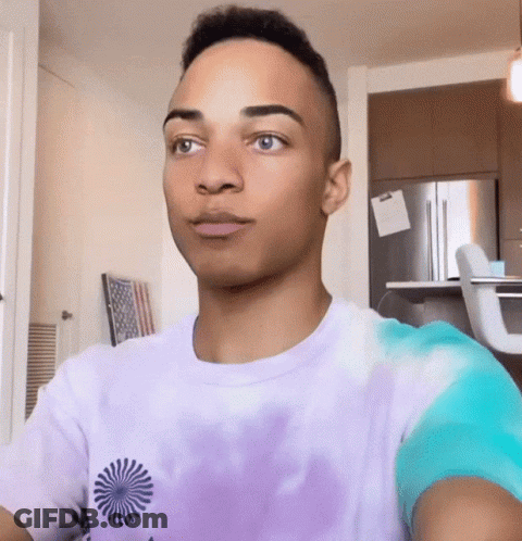 Young Man In Purple Tie Dye Shirt Looking At Camera GIF