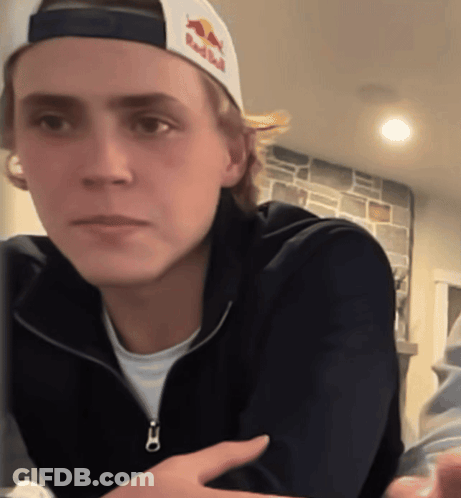 Young Man In Red Bull Hat Looking At Camera GIF