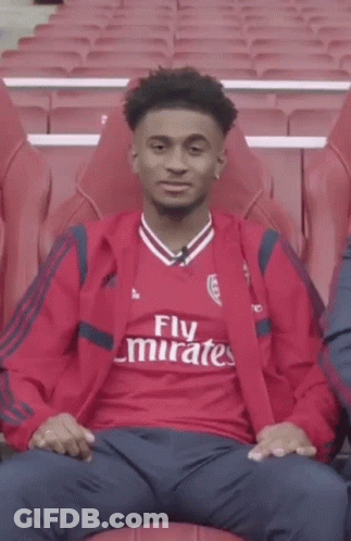 Young Man In Red Emirates Shirt Pointing GIF