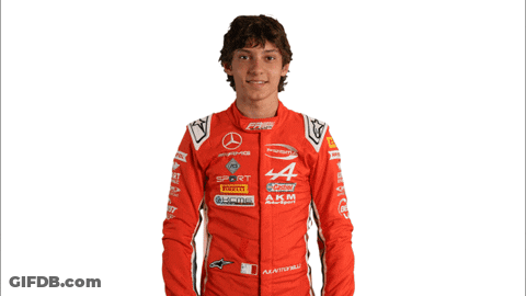 Young Man In Red Racing Suit Holding New Video Sign GIF