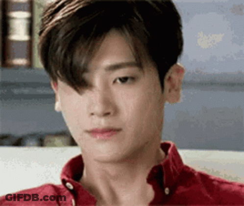 Young Man In Red Shirt Sitting On Couch Looking Down GIF