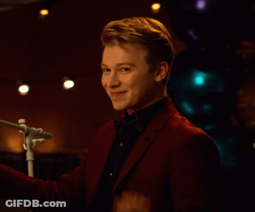 Young Man In Red Suit Waving At Microphone GIF
