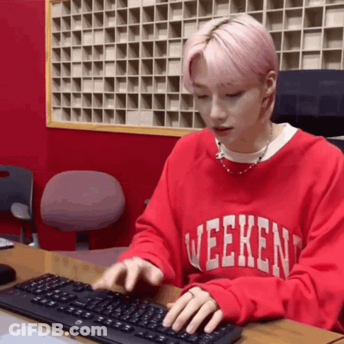 Young Man In Red Sweater Typing On Keyboard GIF