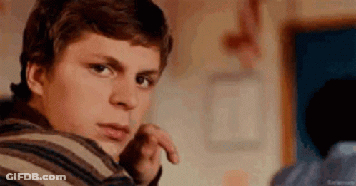 Young Man In Striped Shirt Looking At Camera GIF