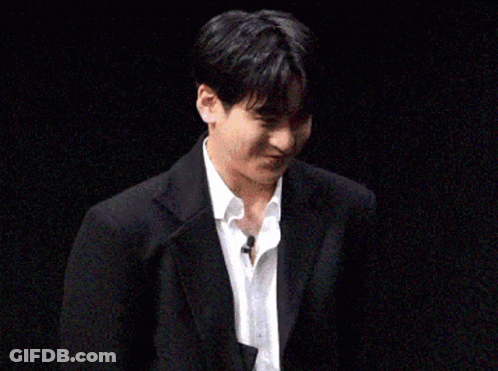 Young Man In Suit And Tie Holding Paper GIF